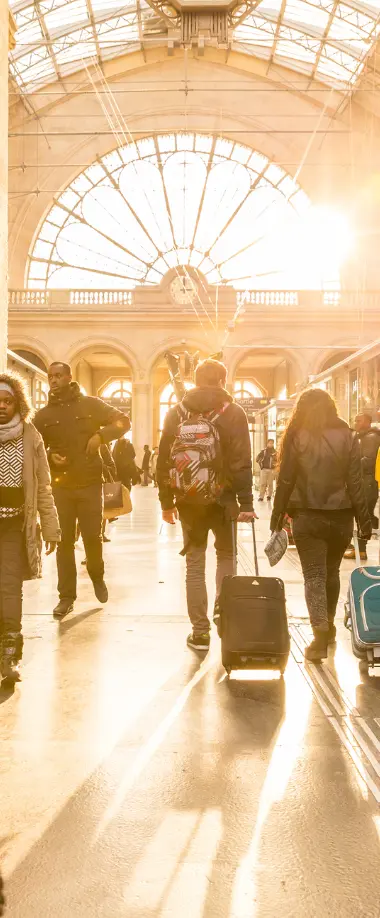 Chauffeur accueillant des passagers devant une grande gare de Lyon